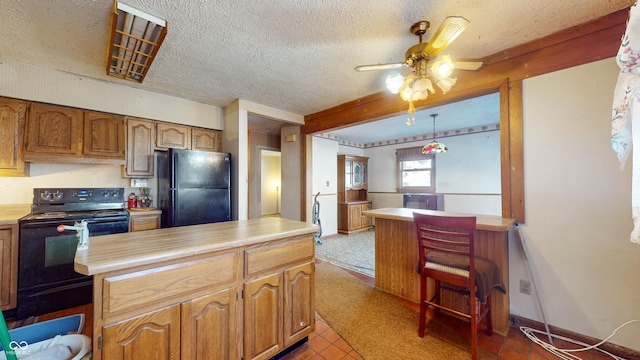 kitchen with light tile patterned floors, ceiling fan, black appliances, a textured ceiling, and decorative light fixtures