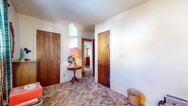 hallway featuring carpet floors and a textured ceiling