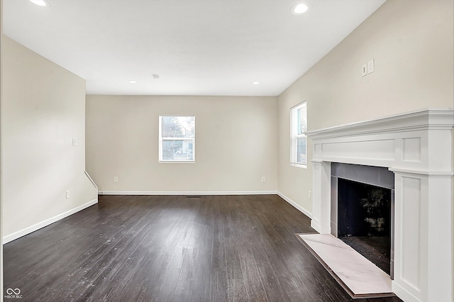 unfurnished living room with recessed lighting, baseboards, dark wood-style flooring, and a tile fireplace