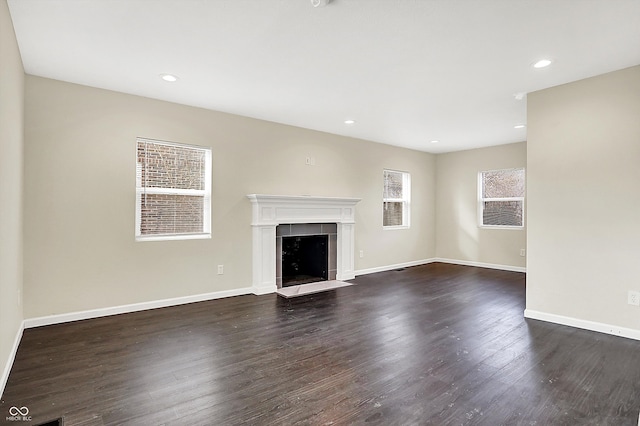 unfurnished living room with a fireplace, baseboards, dark wood-style flooring, and recessed lighting