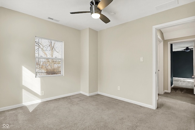 carpeted spare room with a ceiling fan, visible vents, and baseboards