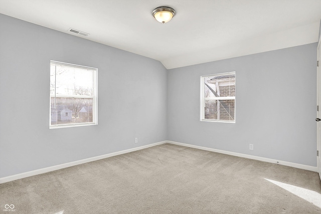 unfurnished room with carpet, visible vents, and plenty of natural light