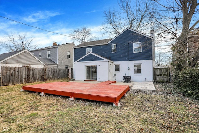 rear view of property with a fenced backyard, central air condition unit, brick siding, a yard, and a wooden deck