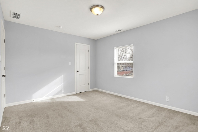 carpeted spare room with baseboards and visible vents