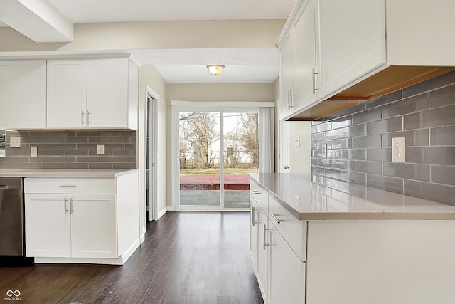 kitchen with dark wood-style floors, light countertops, tasteful backsplash, and white cabinetry