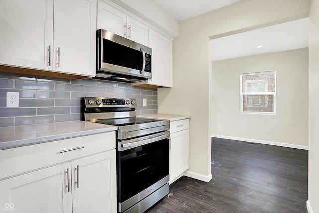 kitchen featuring dark wood-type flooring, baseboards, light countertops, appliances with stainless steel finishes, and backsplash