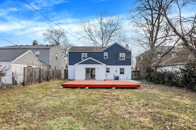 back of property featuring a fenced backyard, a lawn, a wooden deck, and central air condition unit