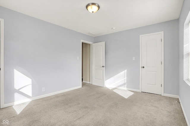 unfurnished room with carpet and baseboards