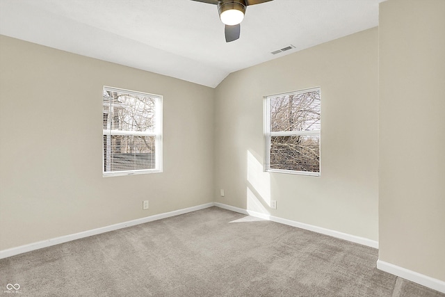 carpeted empty room with lofted ceiling, visible vents, ceiling fan, and baseboards