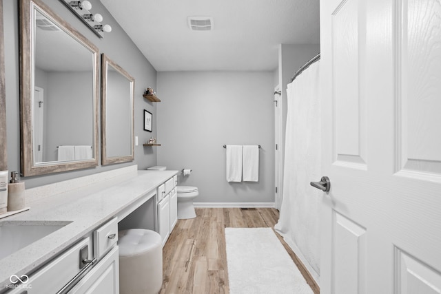 bathroom with vanity, wood-type flooring, and toilet