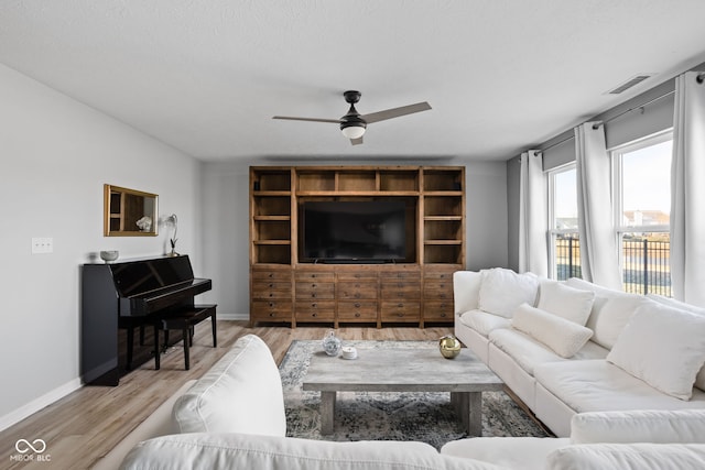 living room with light hardwood / wood-style floors and ceiling fan