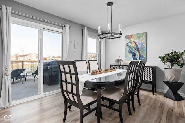 dining room with an inviting chandelier, light hardwood / wood-style flooring, and a textured ceiling