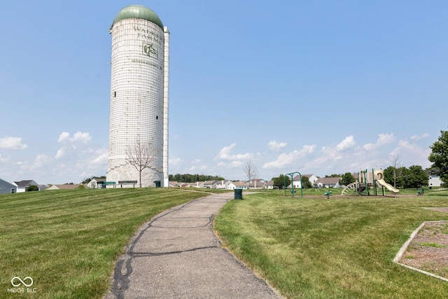 view of property's community featuring a lawn and a playground