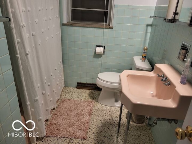 bathroom featuring toilet, sink, tile walls, and a shower with curtain