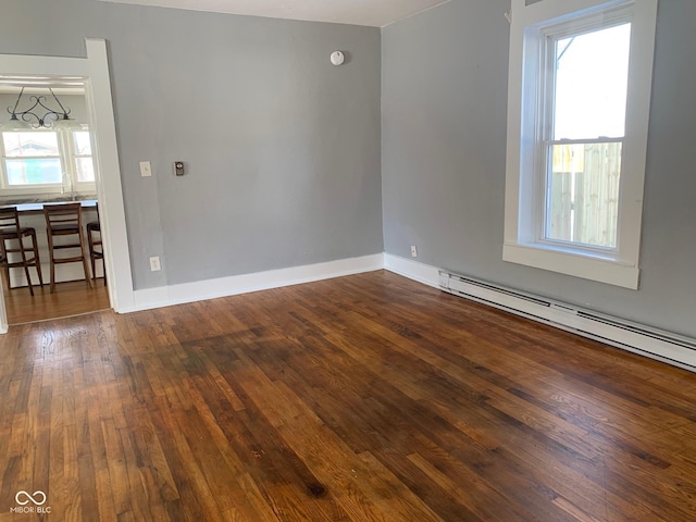 empty room featuring a baseboard radiator and dark hardwood / wood-style flooring