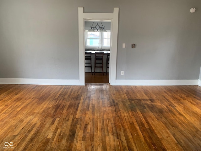 unfurnished room with sink and dark wood-type flooring