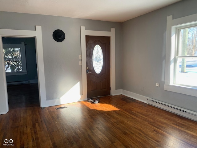 foyer with dark wood-type flooring and baseboard heating