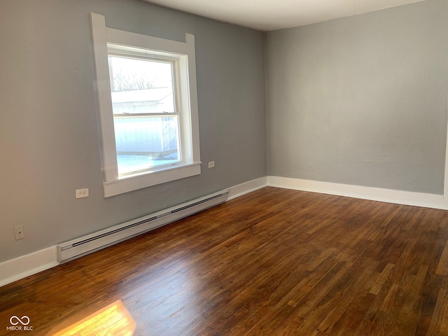 spare room with dark wood-type flooring and baseboard heating