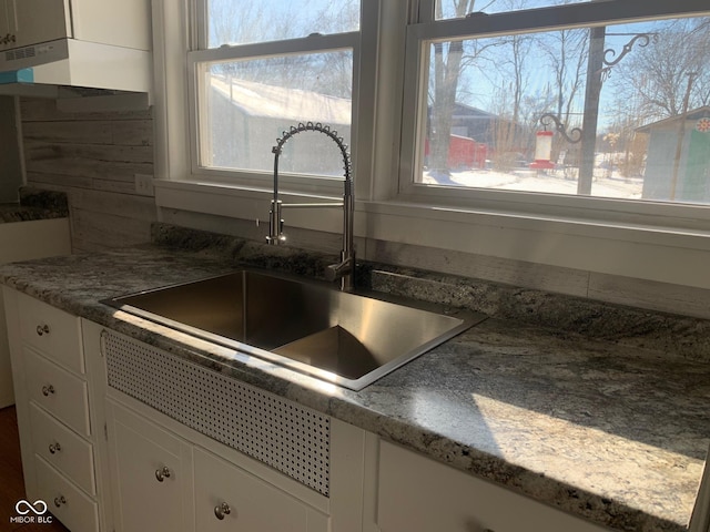 kitchen featuring white cabinetry and sink