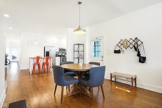 dining area with dark wood-type flooring and a healthy amount of sunlight