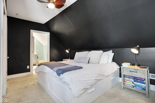 carpeted bedroom featuring vaulted ceiling, connected bathroom, and ceiling fan