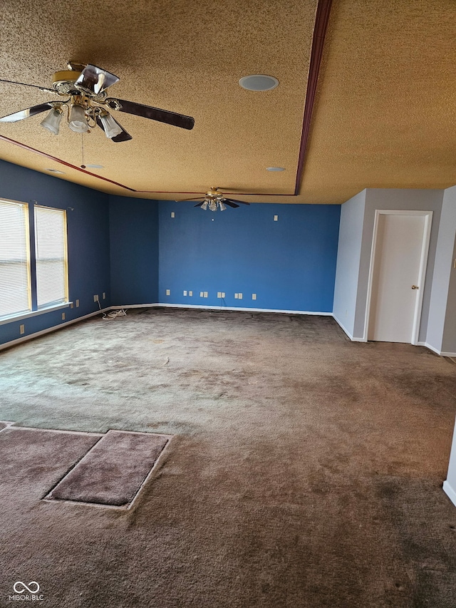 carpeted spare room with a textured ceiling and ceiling fan