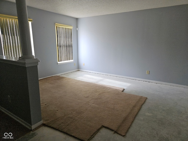 carpeted spare room with a textured ceiling