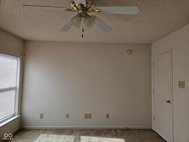 carpeted empty room featuring ceiling fan and a textured ceiling