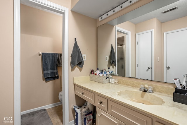 bathroom with walk in shower, vanity, toilet, and tile patterned flooring