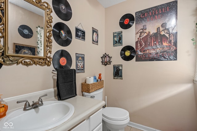 bathroom featuring vanity, tile patterned floors, and toilet