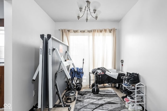 workout area featuring an inviting chandelier