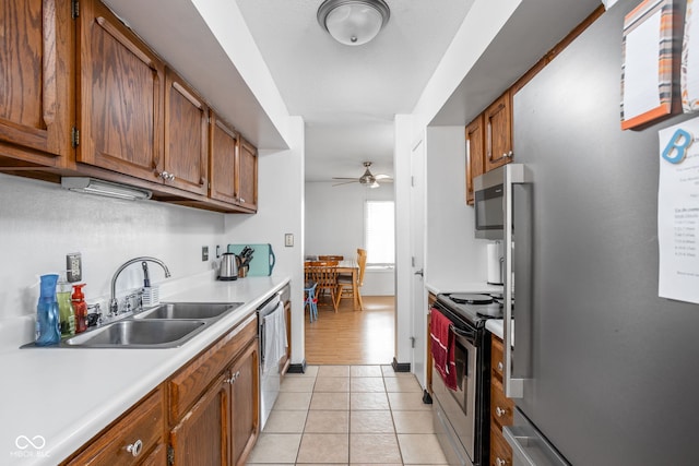 kitchen featuring ceiling fan, stainless steel appliances, sink, and light tile patterned floors