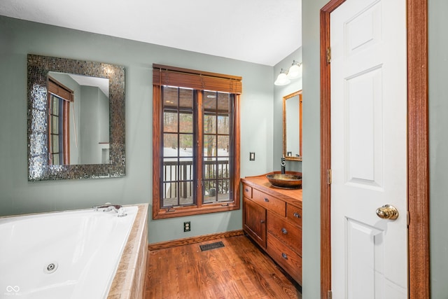 bathroom featuring tiled tub, wood-type flooring, and vanity