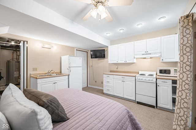 bedroom with water heater, sink, white fridge, light colored carpet, and ceiling fan