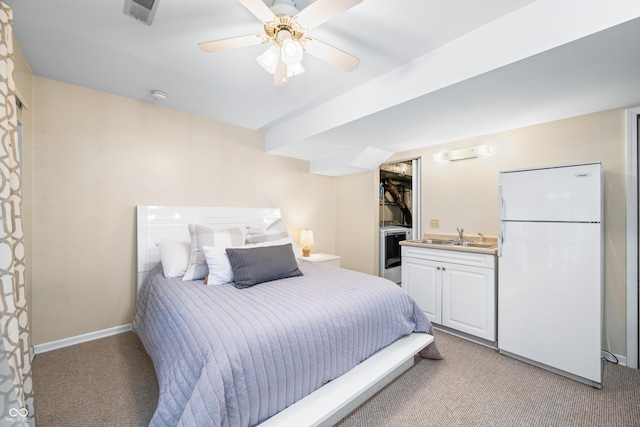 bedroom with sink, light colored carpet, ceiling fan, and white fridge