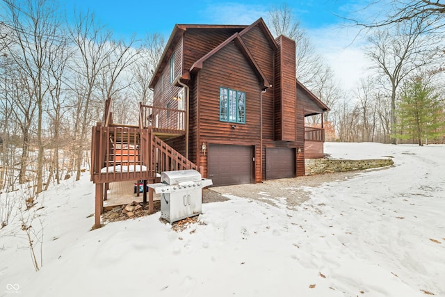 view of snowy exterior featuring a garage