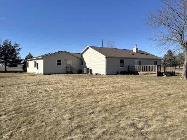 rear view of house with a wooden deck and a lawn