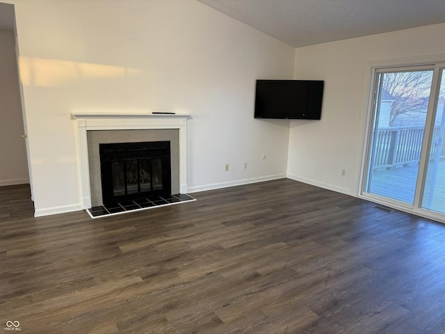 unfurnished living room with a fireplace, dark hardwood / wood-style flooring, and vaulted ceiling