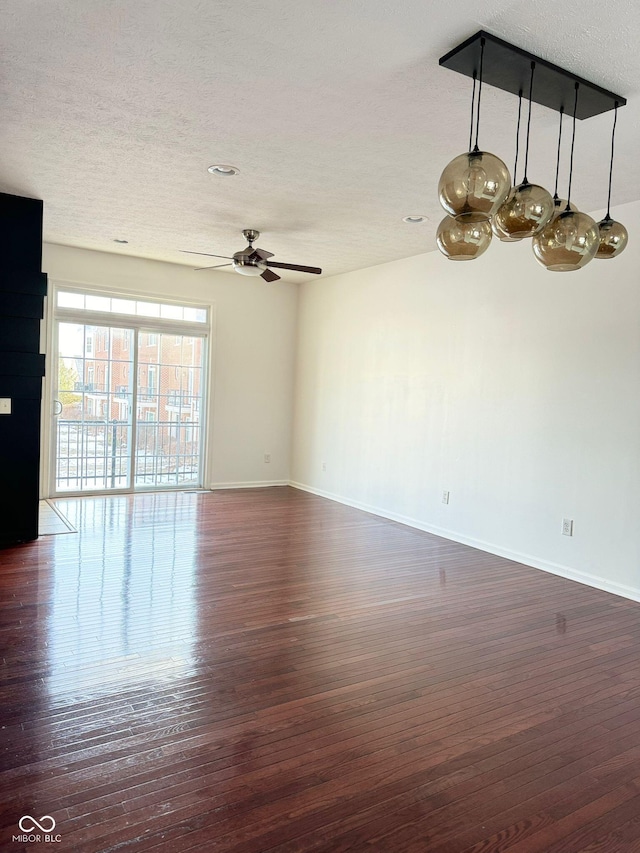 spare room featuring dark hardwood / wood-style floors, a textured ceiling, and ceiling fan