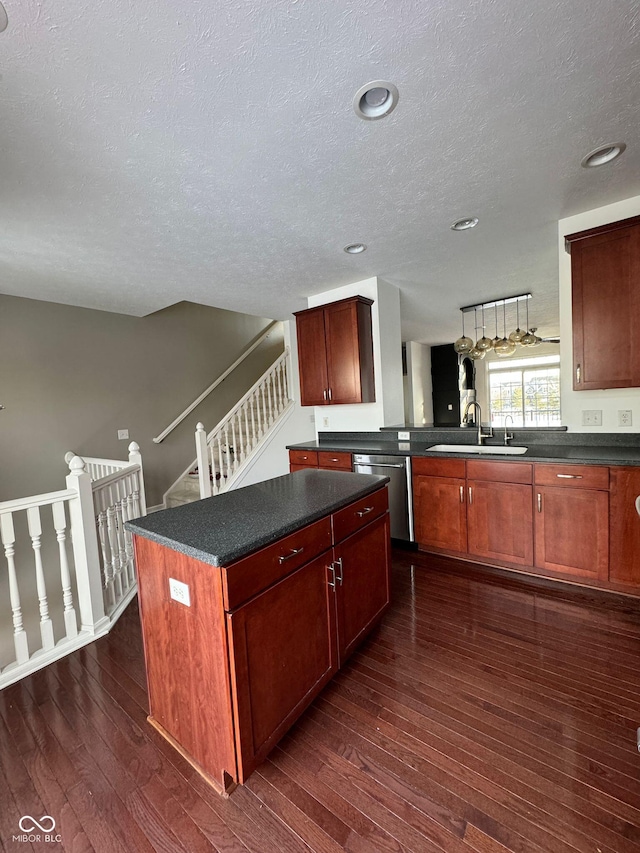 kitchen featuring dishwasher, sink, dark hardwood / wood-style flooring, a center island, and a textured ceiling