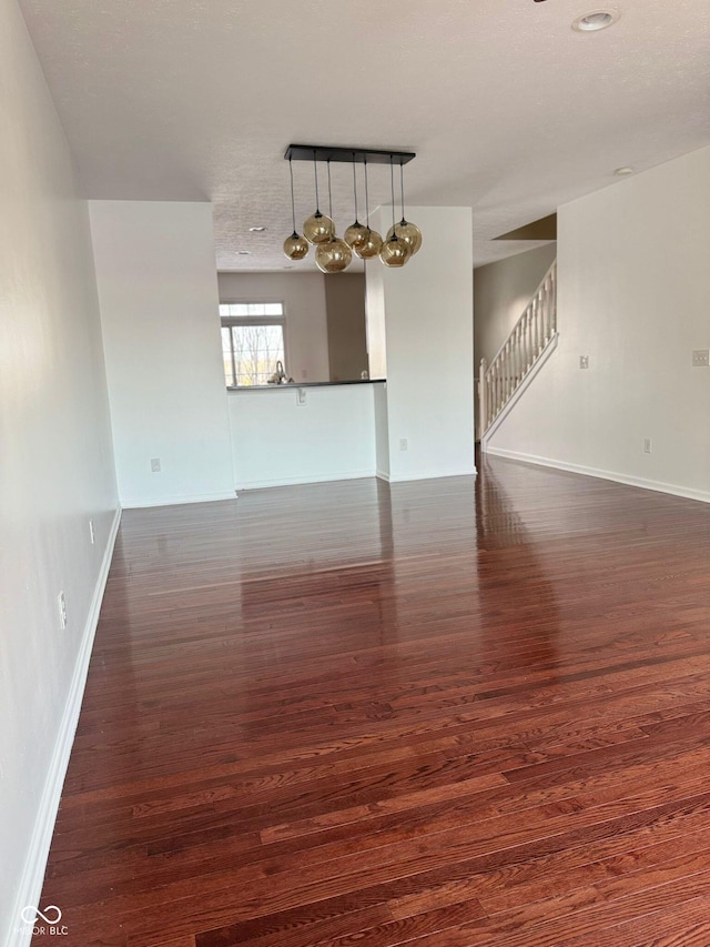 spare room featuring dark hardwood / wood-style floors and track lighting