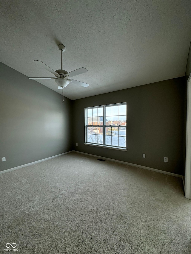 carpeted spare room featuring ceiling fan and a textured ceiling