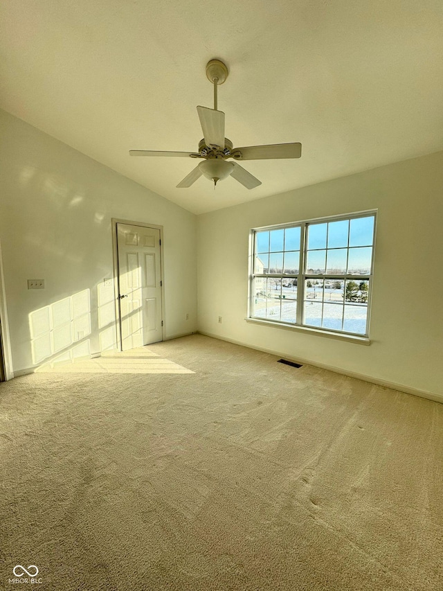 carpeted empty room featuring lofted ceiling and ceiling fan