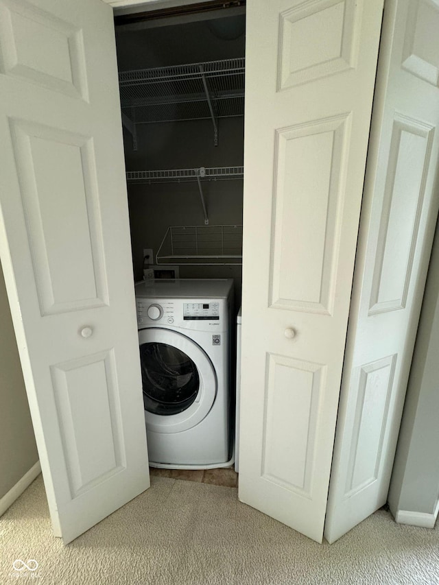 washroom featuring washer / clothes dryer and light carpet