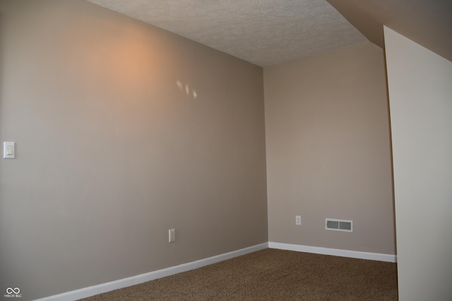 carpeted empty room featuring a textured ceiling