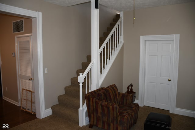 stairway with a textured ceiling