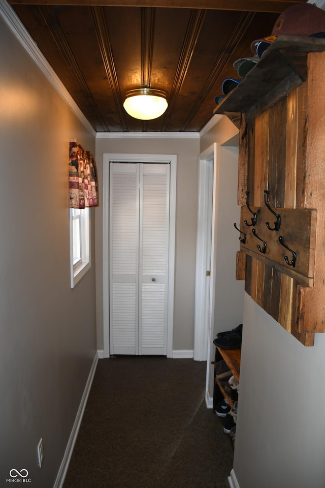 corridor with crown molding, dark carpet, and wooden ceiling