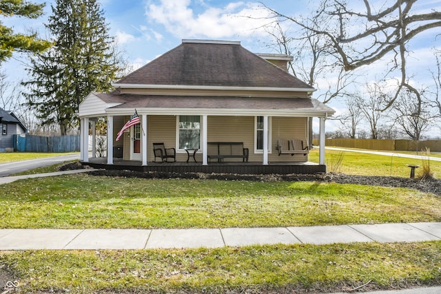 farmhouse inspired home with a front yard and covered porch