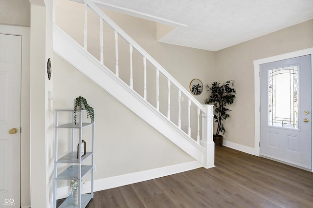 foyer with a textured ceiling and dark hardwood / wood-style flooring