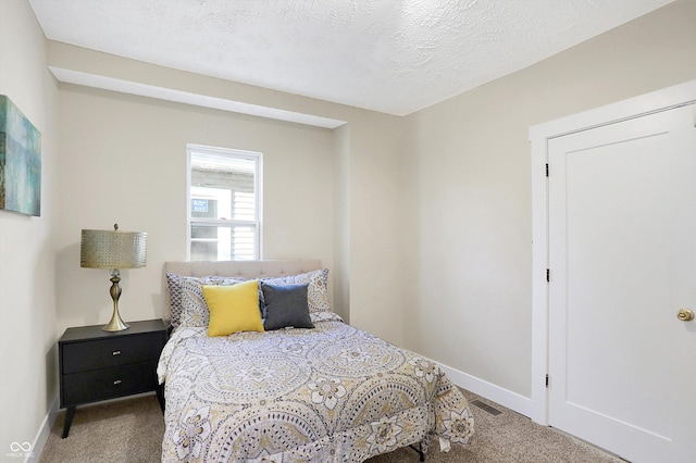 bedroom with carpet floors and a textured ceiling